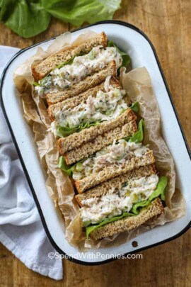 tuna sandwiches cut in half in a tin with lettuce