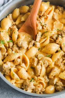 top view of Cheesy Ground Turkey Pasta cooking in a pot with a spoon