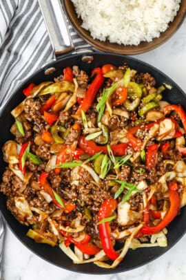 cooked Ground Beef Stir Fry with a bowl of rice beside it