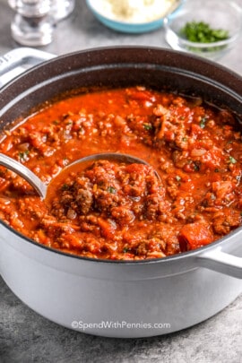 ladle scooping homemade spaghetti sauce with text
