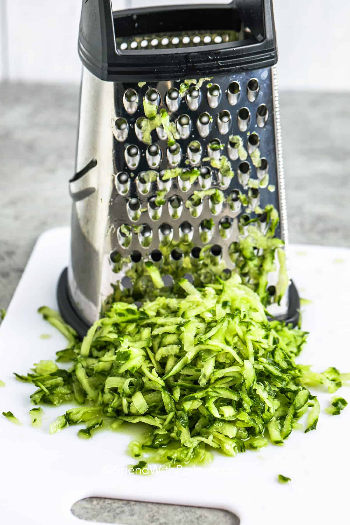 shredding cucumber to make Tzatziki Sauce