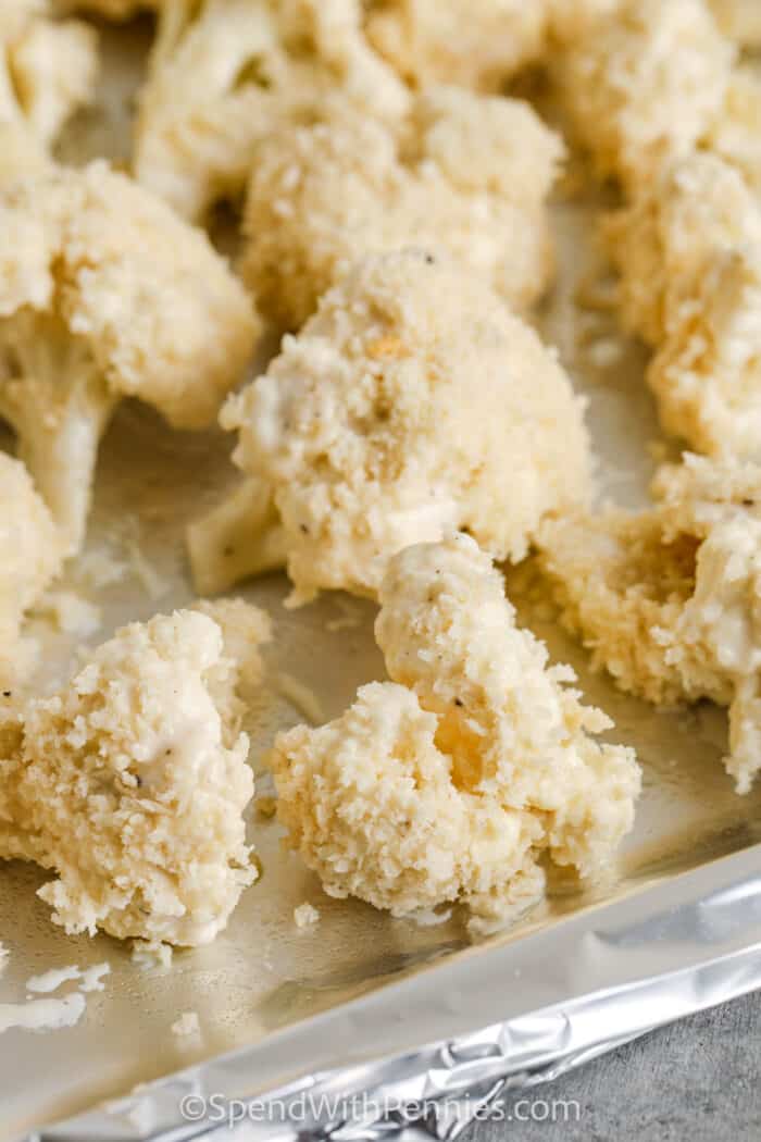 coated cauliflower on sheet pan to make Oven Baked Buffalo Cauliflower