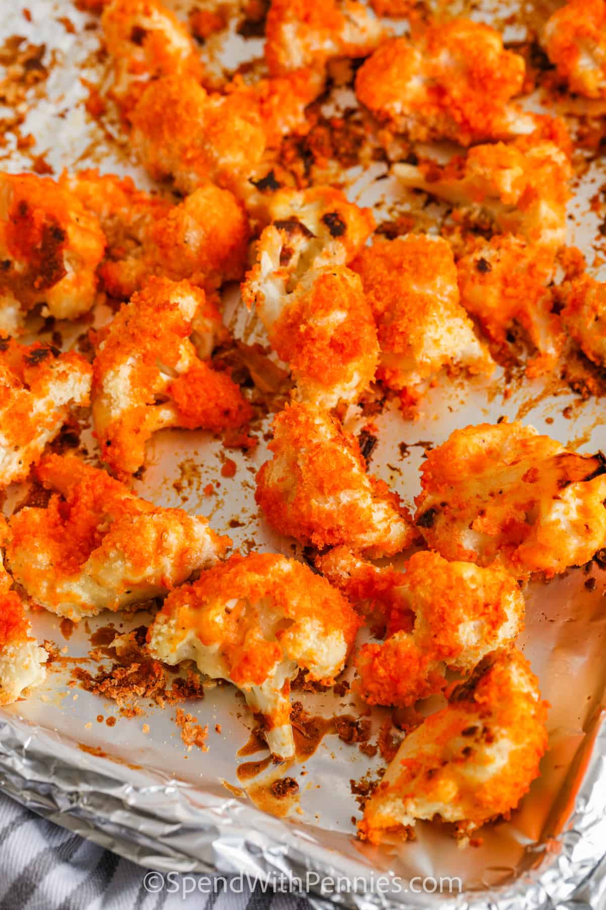cauliflower with buffalo sauce on a sheet pan to make Oven Baked Buffalo Cauliflower