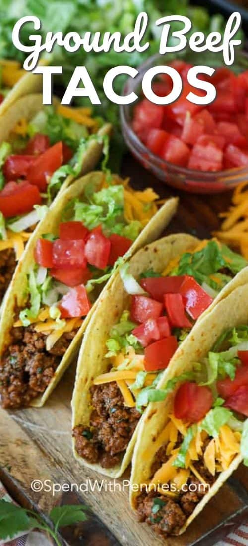 Ground beef tacos on a wooden board with a title