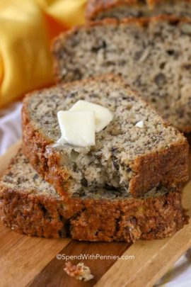 Banana bread on a cutting board with pats of butter