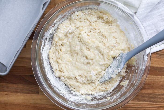 Lumpy banana bread batter in a glass bowl