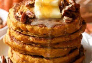 Pouring syrup over a stack of Pumpkin Pancakes