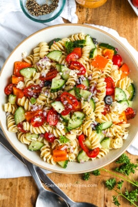 an an easy pasta salad in a white serving bowl with parsley