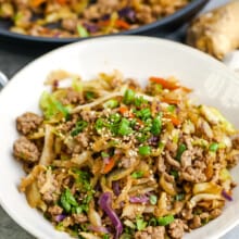 egg roll in a bowl garnished with green onions and sesame seeds
