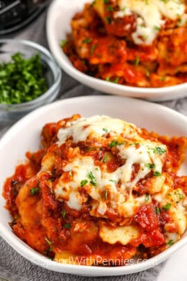 ravioli in a bowl topped with cheese and parsley